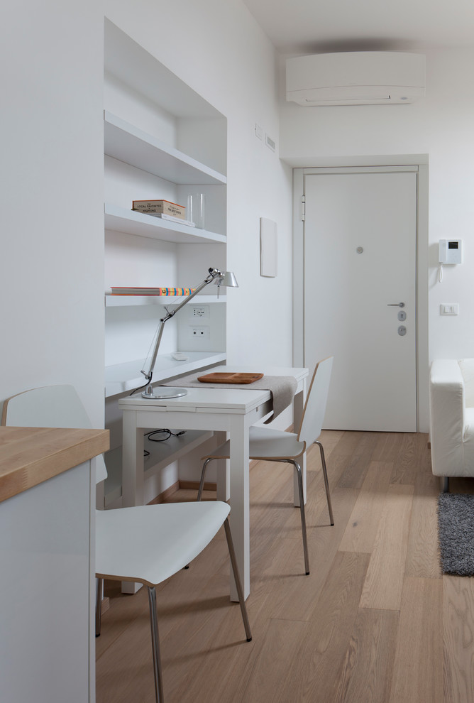 Cette photo montre un petit bureau scandinave de type studio avec un mur blanc, un sol en bois brun et un bureau indépendant.