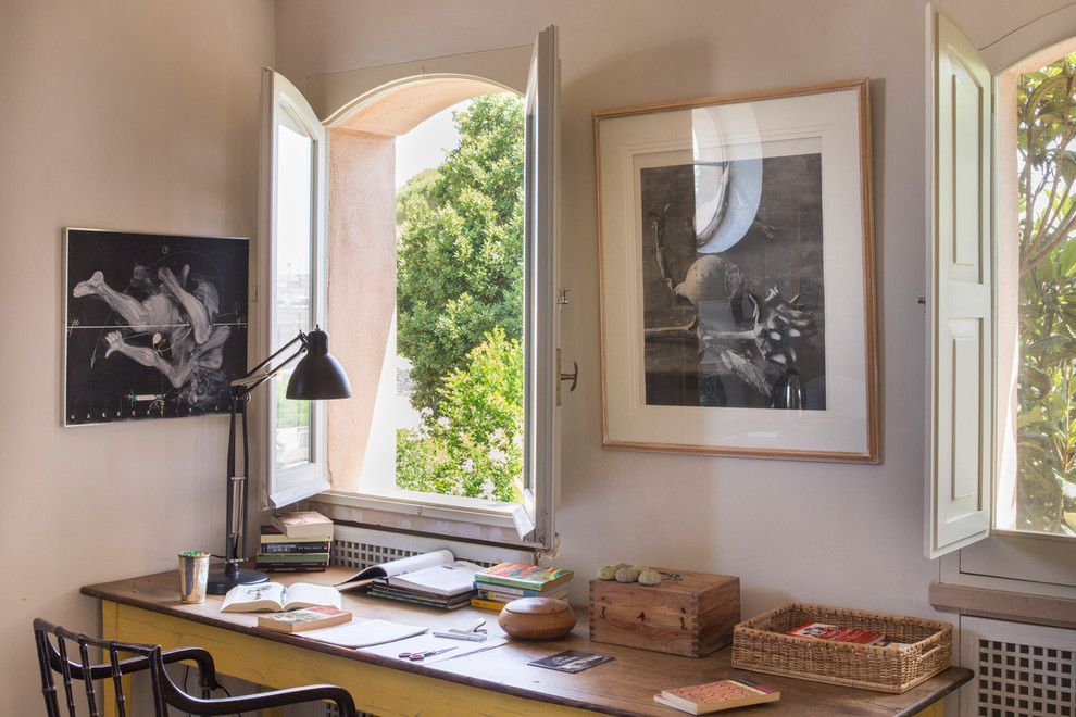 Idee per un ampio studio mediterraneo con pareti beige, pavimento beige e libreria