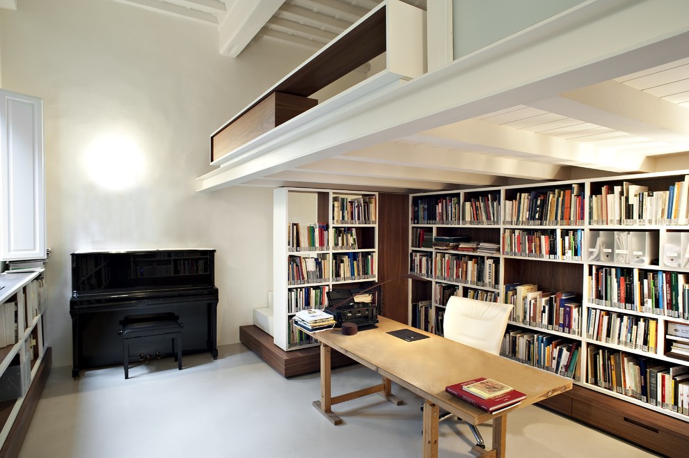 Réalisation d'un bureau urbain avec une bibliothèque ou un coin lecture, un mur blanc, un bureau indépendant et un sol gris.