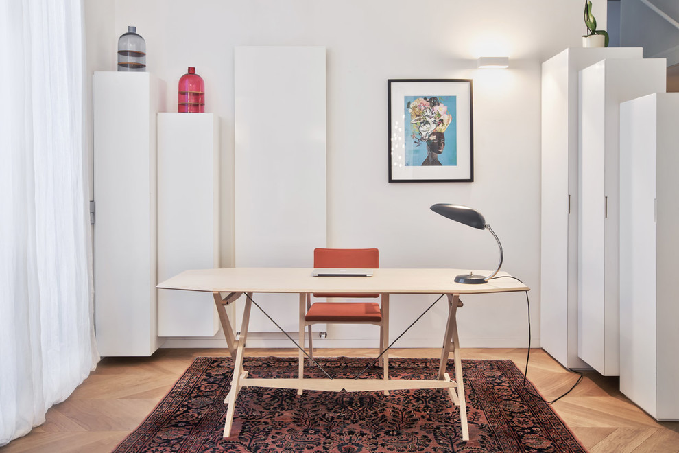 Cette image montre un bureau design de taille moyenne et de type studio avec un mur blanc, parquet clair et un bureau indépendant.