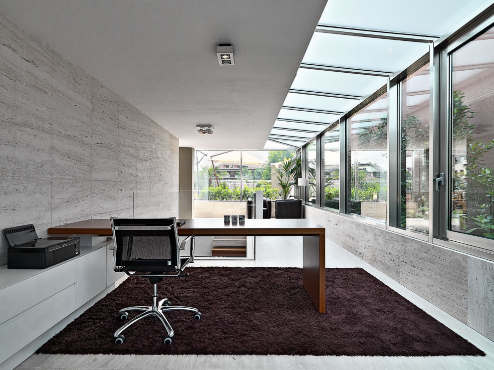 На фото: рабочее место среднего размера в современном стиле с серыми стенами, отдельно стоящим рабочим столом и серым полом