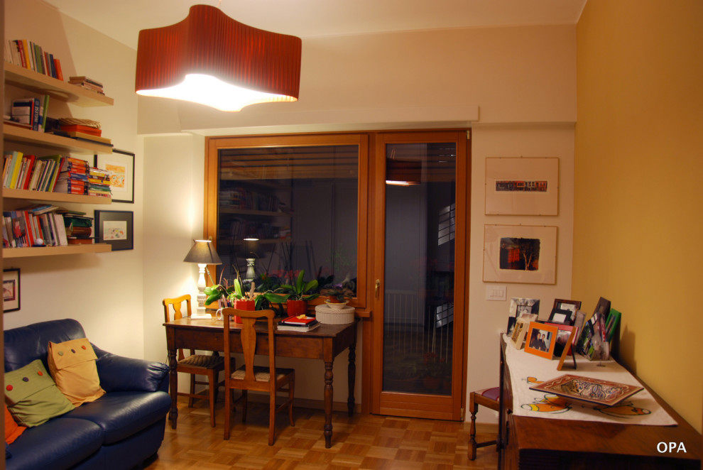 Réalisation d'un grand bureau tradition de type studio avec un mur jaune, un bureau indépendant et un sol en bois brun.