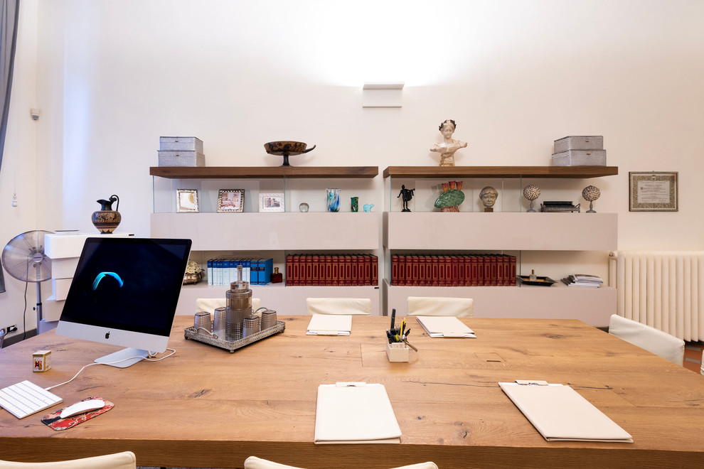 Immagine di un grande ufficio minimalista con pareti bianche, pavimento in terracotta, camino classico, cornice del camino in cemento, scrivania autoportante e pavimento marrone
