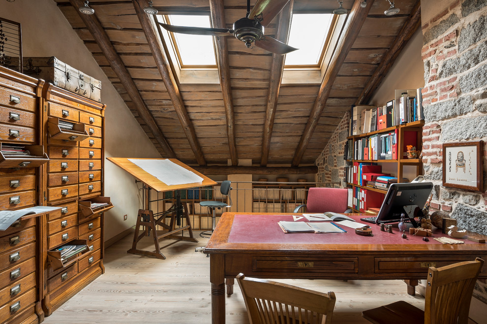 Imagen de estudio bohemio de tamaño medio con paredes beige, suelo de madera clara y escritorio independiente