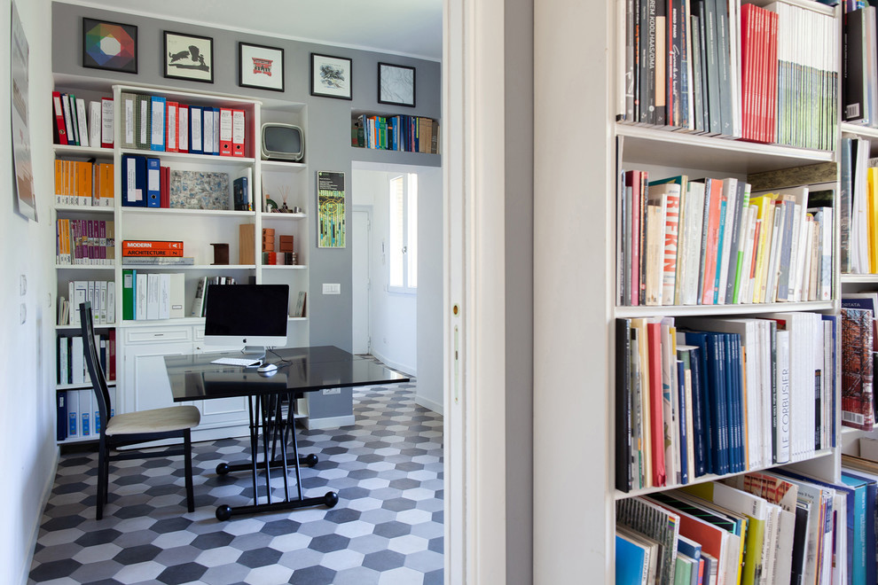 Idéer för funkis arbetsrum, med ett bibliotek, grå väggar, klinkergolv i porslin, ett fristående skrivbord och grått golv