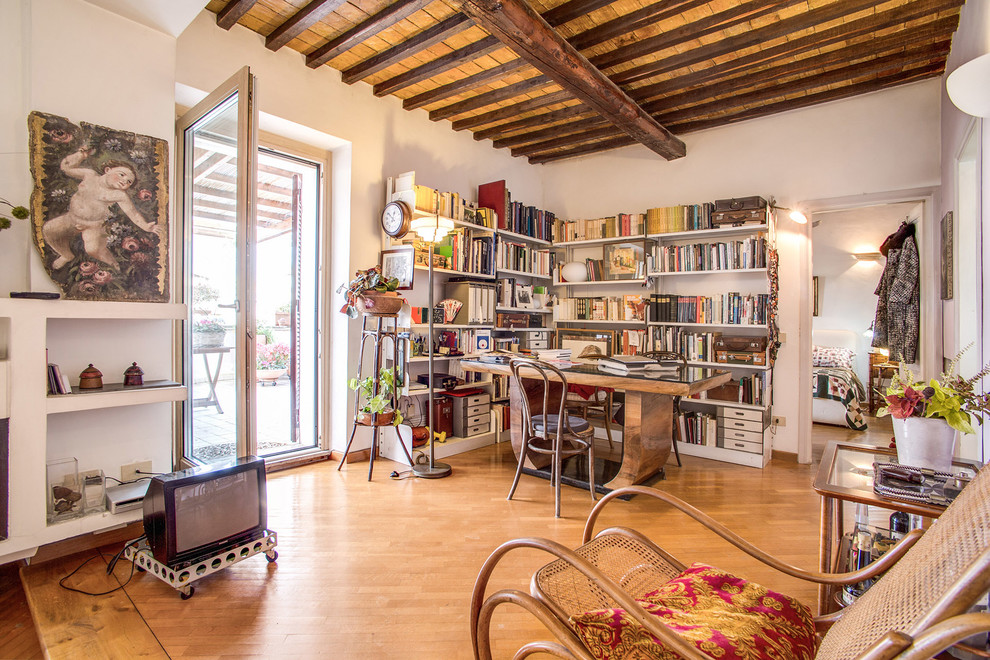 Immagine di uno studio boho chic di medie dimensioni con pareti bianche, pavimento in legno massello medio, scrivania autoportante, libreria e pavimento marrone