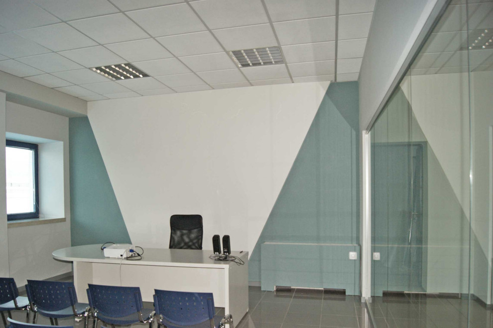 Ejemplo de despacho minimalista grande con escritorio independiente y suelo gris