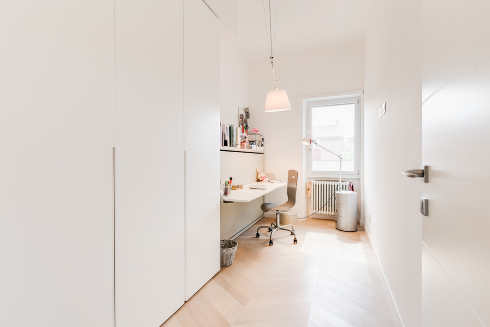 Immagine di un piccolo studio design con pareti bianche, parquet chiaro e pavimento beige