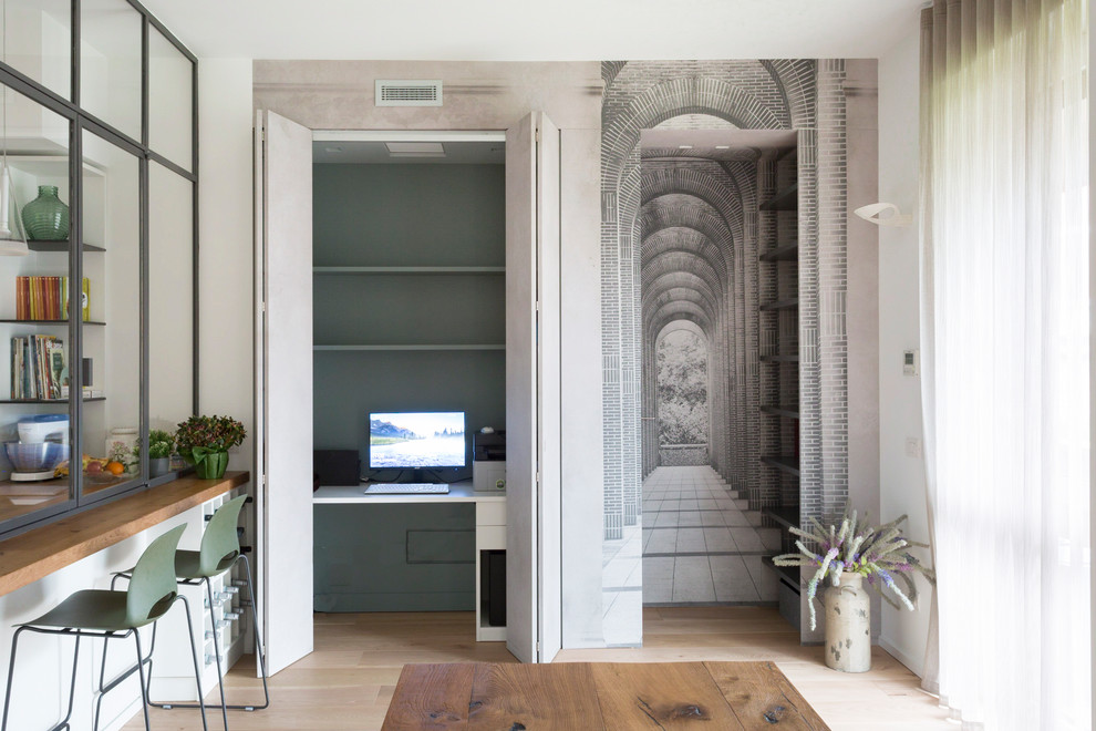Ejemplo de despacho contemporáneo grande con paredes multicolor, suelo de madera clara, escritorio empotrado y suelo beige