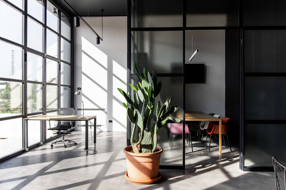 Foto di un ufficio design di medie dimensioni con pareti nere, pavimento in cemento, scrivania autoportante e pavimento grigio