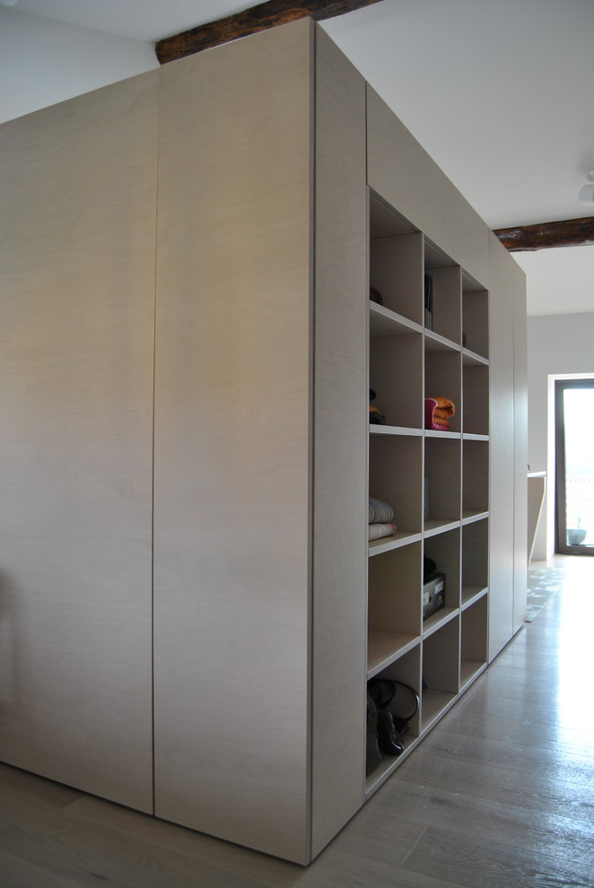 Imagen de estudio actual pequeño con paredes blancas, suelo de madera clara, escritorio independiente y suelo beige