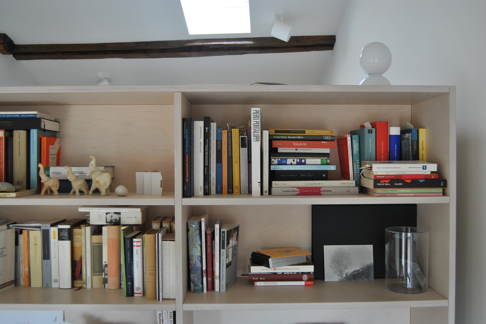 Modern inredning av ett litet hemmastudio, med vita väggar, ljust trägolv, ett fristående skrivbord och beiget golv
