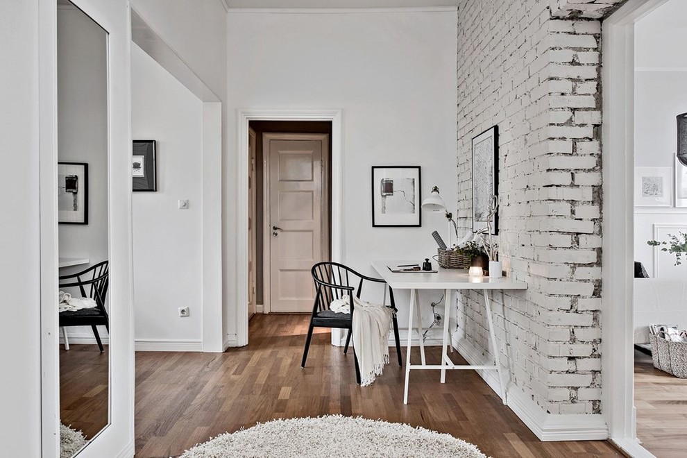 Idee per uno studio scandinavo con pareti bianche, pavimento in legno massello medio e scrivania autoportante