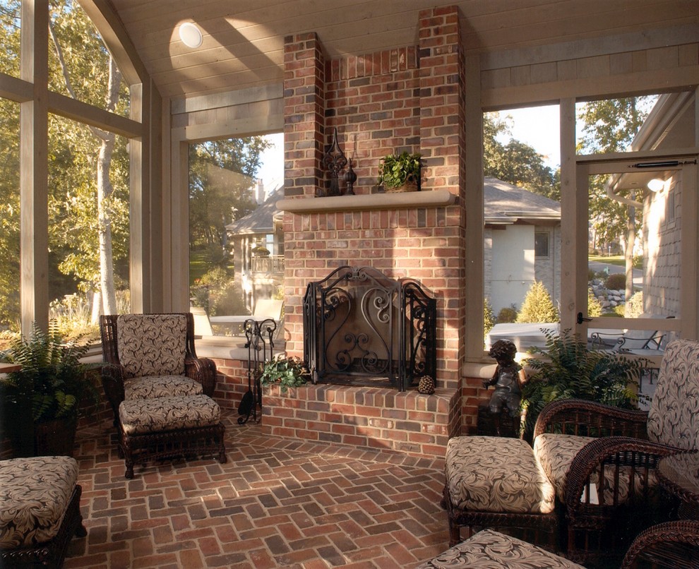 Esempio di una grande veranda classica con pavimento in mattoni, cornice del camino in mattoni e soffitto classico