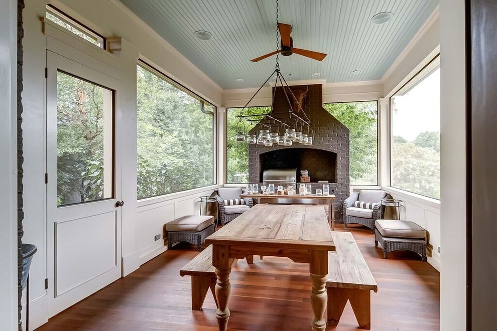 Esempio di una veranda country di medie dimensioni con pavimento in legno massello medio, soffitto classico e pavimento marrone