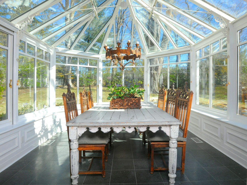 Пример оригинального дизайна: терраса в стиле кантри с стеклянным потолком и черным полом без камина