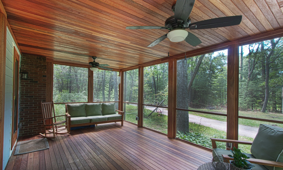 Cette image montre une véranda design de taille moyenne avec un sol en bois brun, aucune cheminée, un plafond standard et un sol marron.