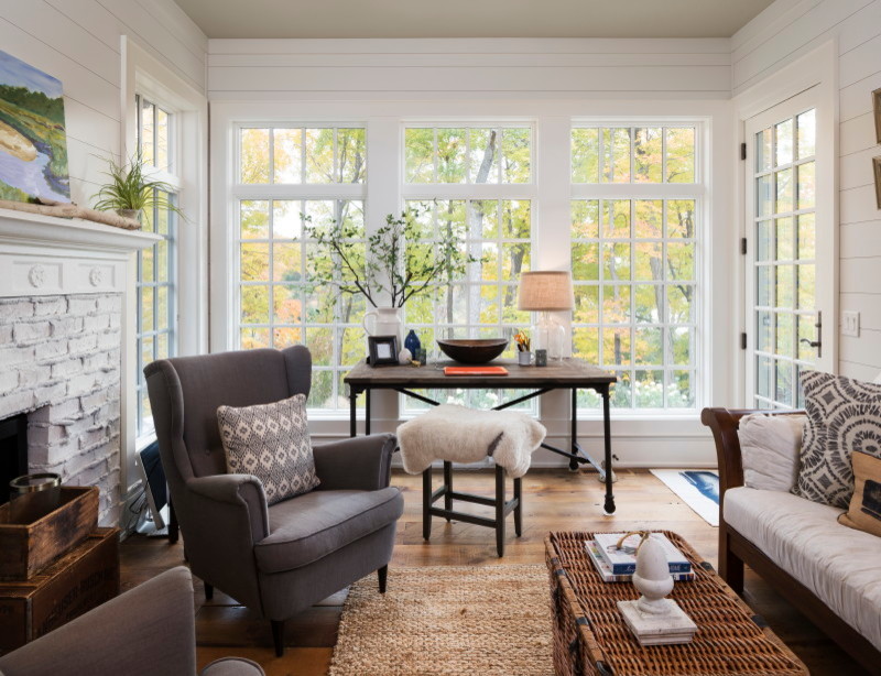 Inspiration for an eclectic conservatory with medium hardwood flooring, a standard fireplace, a brick fireplace surround, a standard ceiling and brown floors.