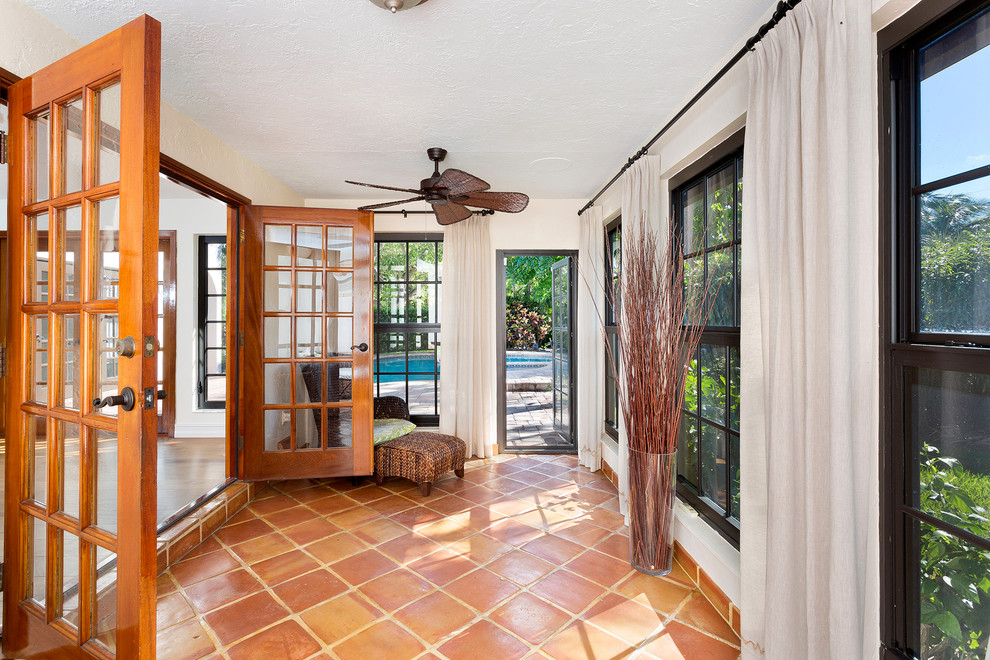 Esempio di una veranda tropicale con pavimento con piastrelle in ceramica, soffitto classico e pavimento rosso