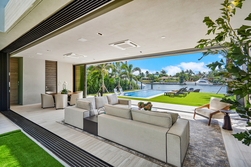 Expansive contemporary conservatory in Miami with porcelain flooring and beige floors.