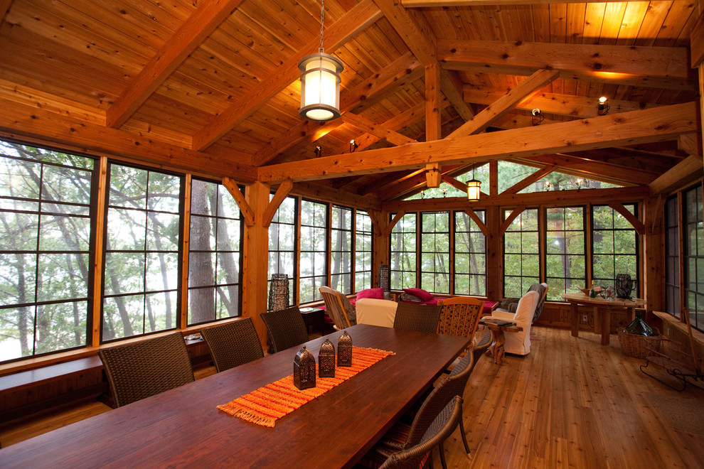 Foto di una grande veranda american style con pavimento in legno massello medio, nessun camino, soffitto classico e pavimento marrone