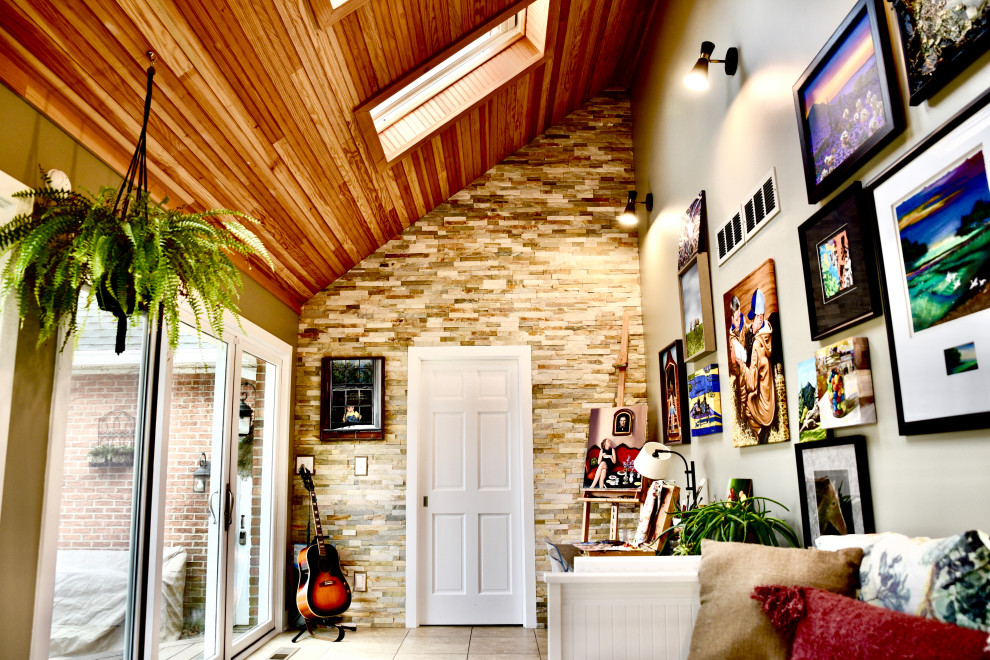 Foto de galería ecléctica de tamaño medio con suelo de baldosas de porcelana, techo con claraboya y suelo beige