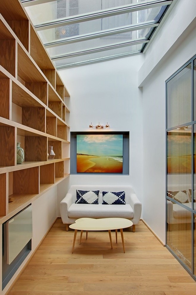 Foto de galería actual de tamaño medio sin chimenea con suelo de madera en tonos medios y techo de vidrio