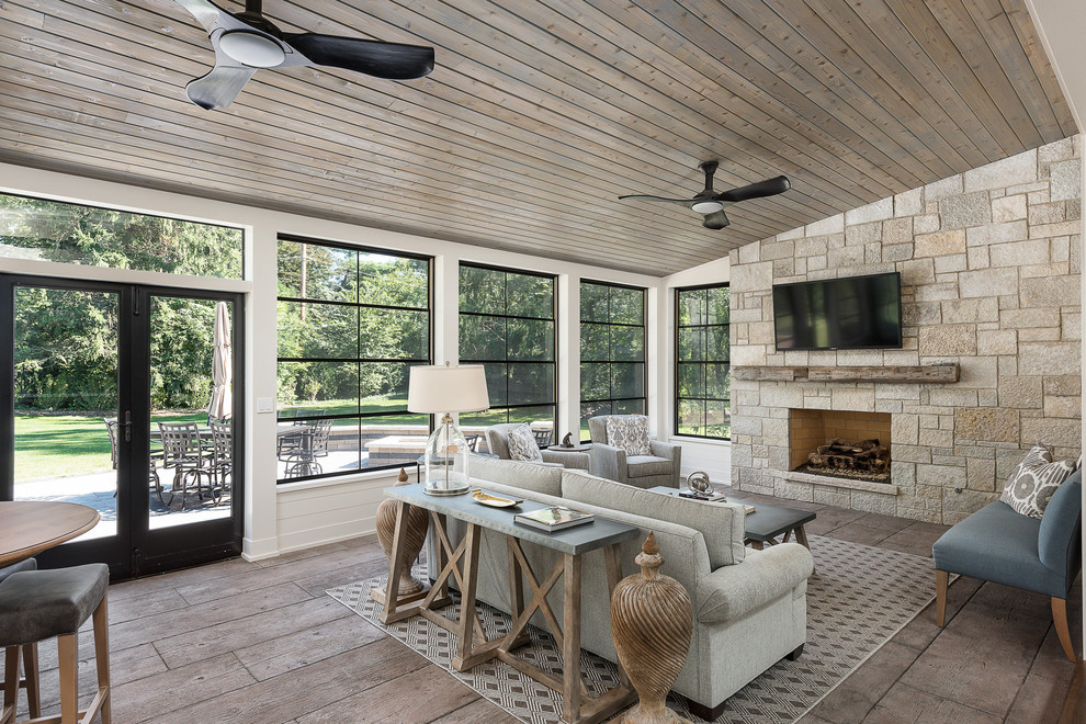 Example of a huge arts and crafts ceramic tile and brown floor sunroom design in Chicago with a standard fireplace, a stone fireplace and a standard ceiling