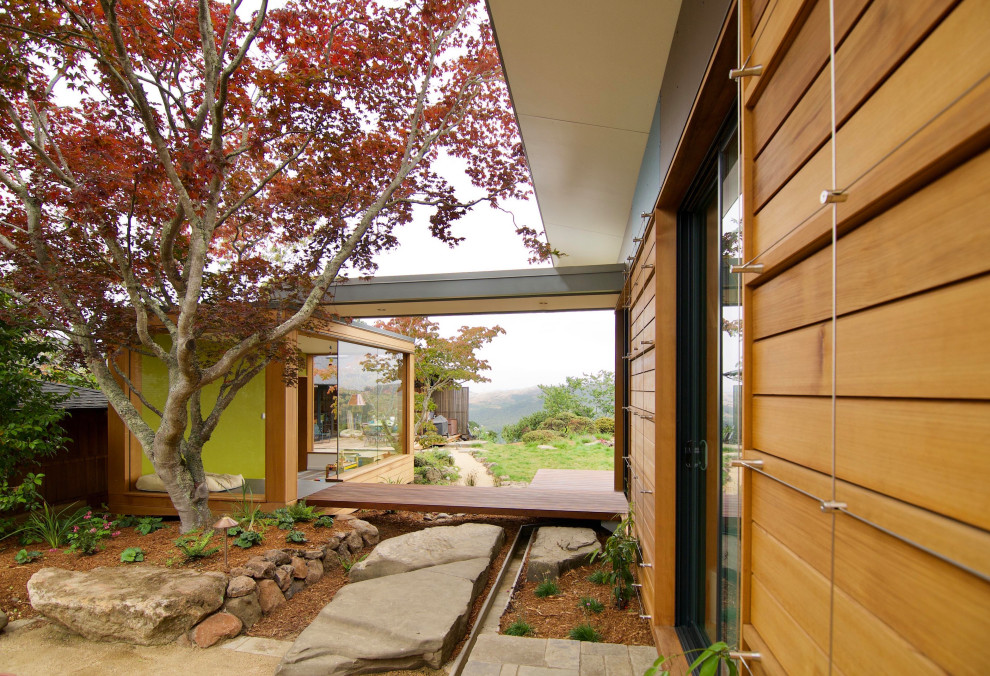 Immagine di un portico minimalista di medie dimensioni e nel cortile laterale con un portico chiuso, pedane, un tetto a sbalzo e parapetto in metallo