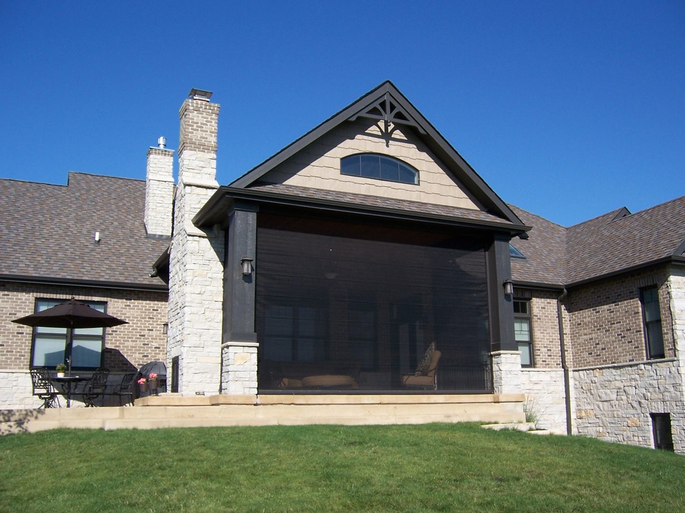На фото: терраса среднего размера в классическом стиле с бетонным полом, двусторонним камином, фасадом камина из камня, стандартным потолком и серым полом