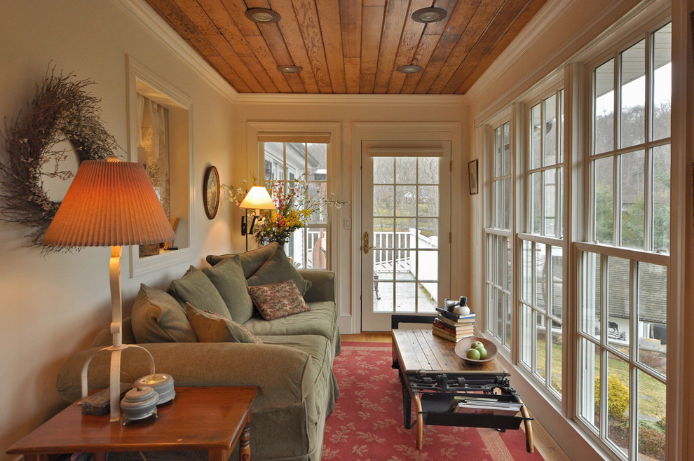 Idée de décoration pour une petite véranda tradition avec un sol en bois brun et un plafond standard.