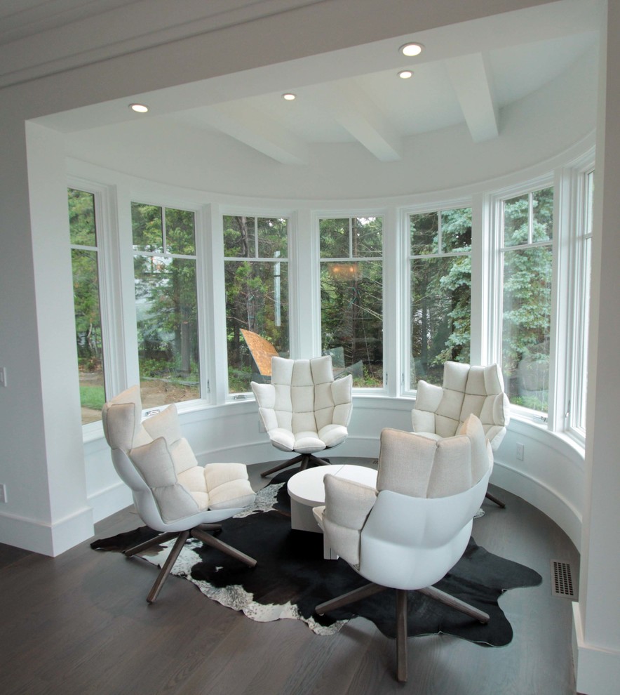 Photo of a large modern conservatory in New York with dark hardwood flooring.
