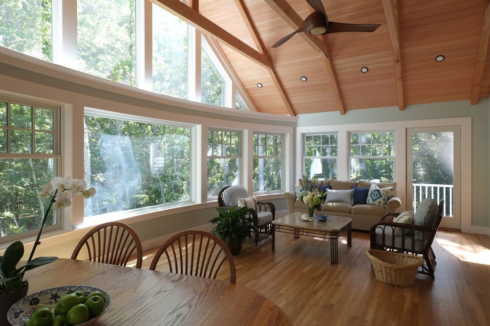 Large traditional conservatory in Boston with medium hardwood flooring, no fireplace, a standard ceiling and brown floors.