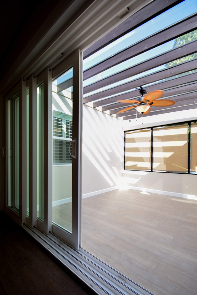 Idee per una piccola veranda country con pavimento in vinile, soffitto in vetro e pavimento marrone