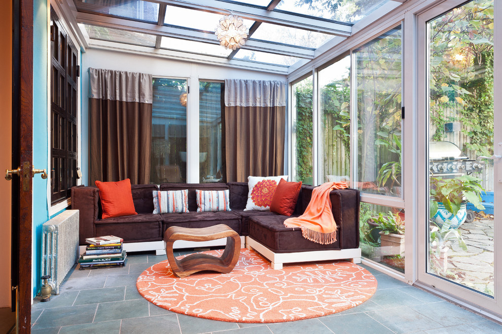Inspiration for a bohemian conservatory in New York with a glass ceiling and grey floors.