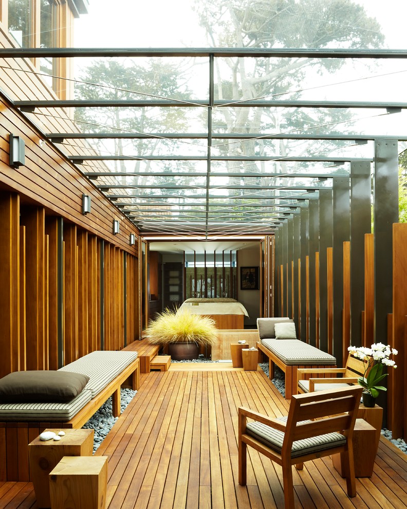 Foto di una veranda design con parquet chiaro e soffitto in vetro