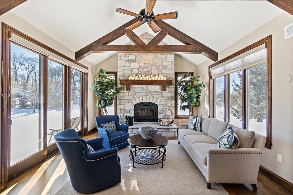 Example of a large mountain style medium tone wood floor and brown floor sunroom design in Charleston with a standard fireplace, a stone fireplace and a standard ceiling