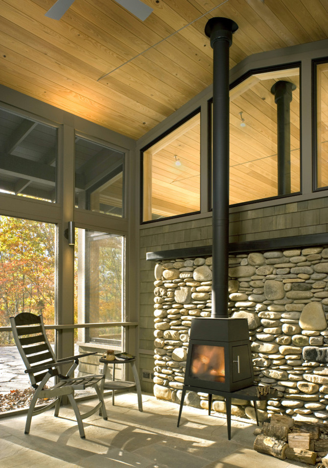 Foto di una piccola veranda moderna con stufa a legna, soffitto classico e cornice del camino in pietra