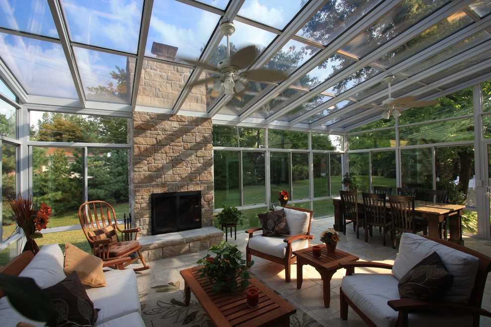 Aménagement d'une grande véranda moderne avec un sol en carrelage de céramique, une cheminée ribbon, un manteau de cheminée en pierre et un plafond en verre.