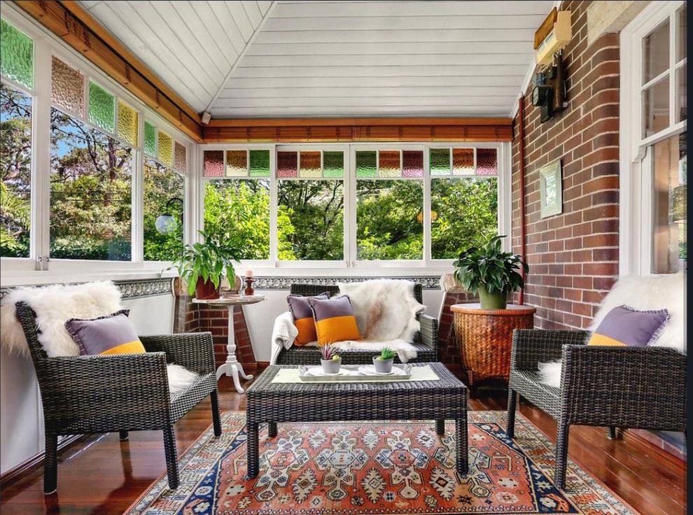 This is an example of a medium sized classic conservatory in Sydney with medium hardwood flooring, a standard ceiling and brown floors.