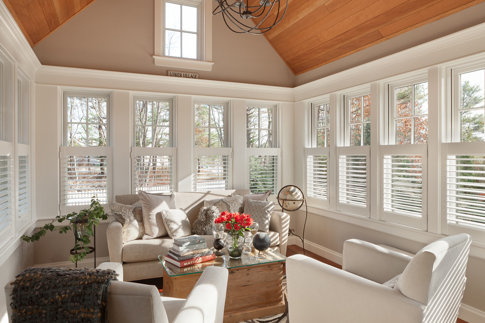 Large traditional conservatory in Portland Maine with medium hardwood flooring, a standard ceiling and brown floors.