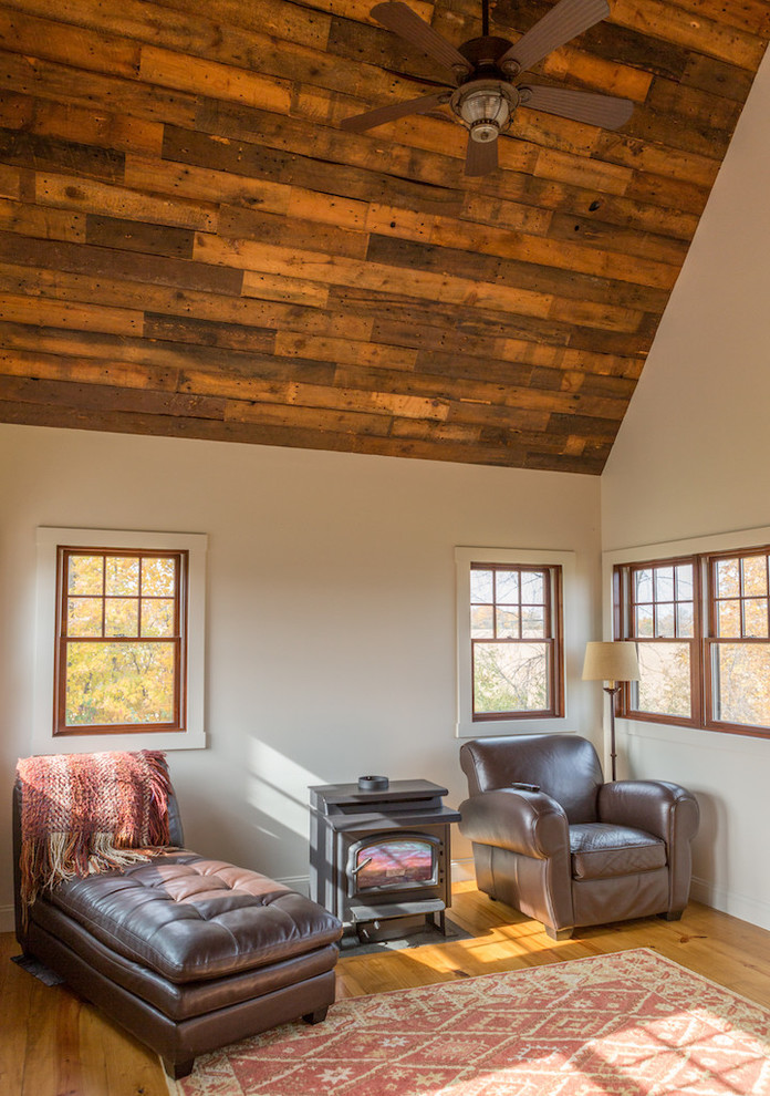 Aménagement d'une véranda campagne de taille moyenne avec un poêle à bois, parquet clair, un plafond standard et un manteau de cheminée en métal.