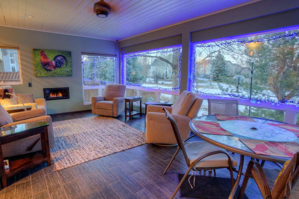 Example of a large trendy medium tone wood floor and brown floor sunroom design in Denver with a metal fireplace, a standard ceiling and a standard fireplace