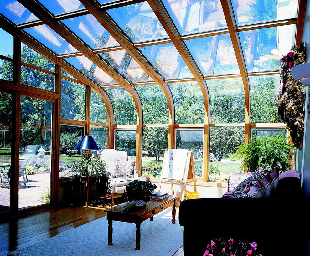 Foto di una veranda contemporanea di medie dimensioni con pavimento in legno massello medio, nessun camino, soffitto in vetro e pavimento marrone