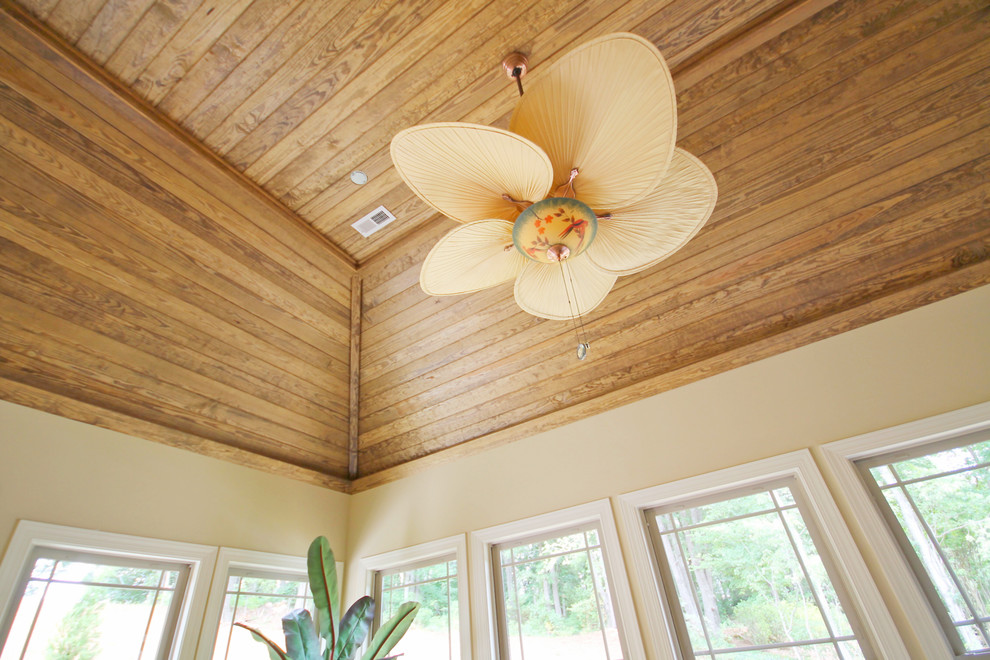 Réalisation d'une véranda tradition avec un sol en bois brun et un plafond standard.