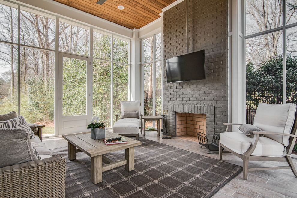 Inspiration for a transitional light wood floor and gray floor sunroom remodel in Charlotte with a standard fireplace and a standard ceiling