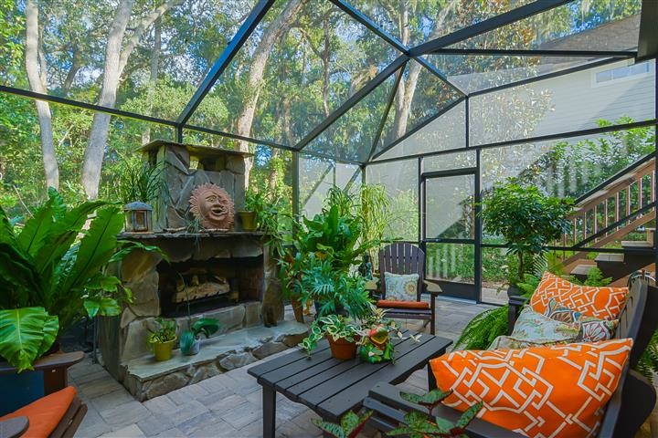 World-inspired conservatory in Jacksonville with slate flooring, a standard fireplace, a stone fireplace surround and a skylight.