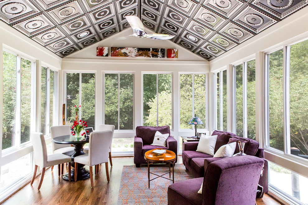 Idée de décoration pour une véranda design de taille moyenne avec un sol en bois brun et un plafond standard.