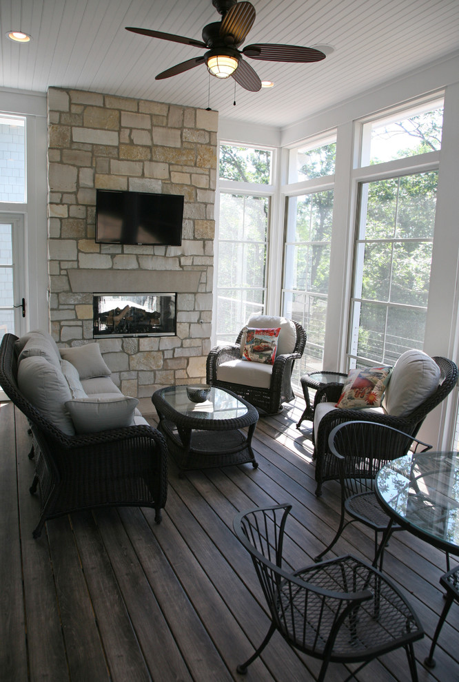 Example of a classic sunroom design in Milwaukee with a two-sided fireplace, a stone fireplace and a standard ceiling