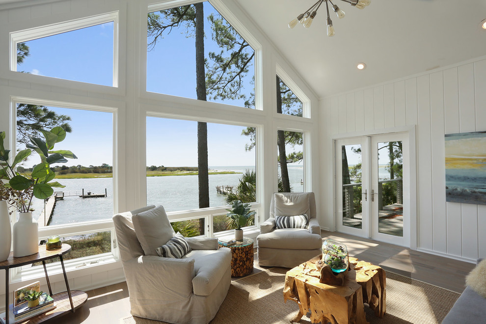 This is an example of a large classic conservatory in Charleston with light hardwood flooring and a standard ceiling.